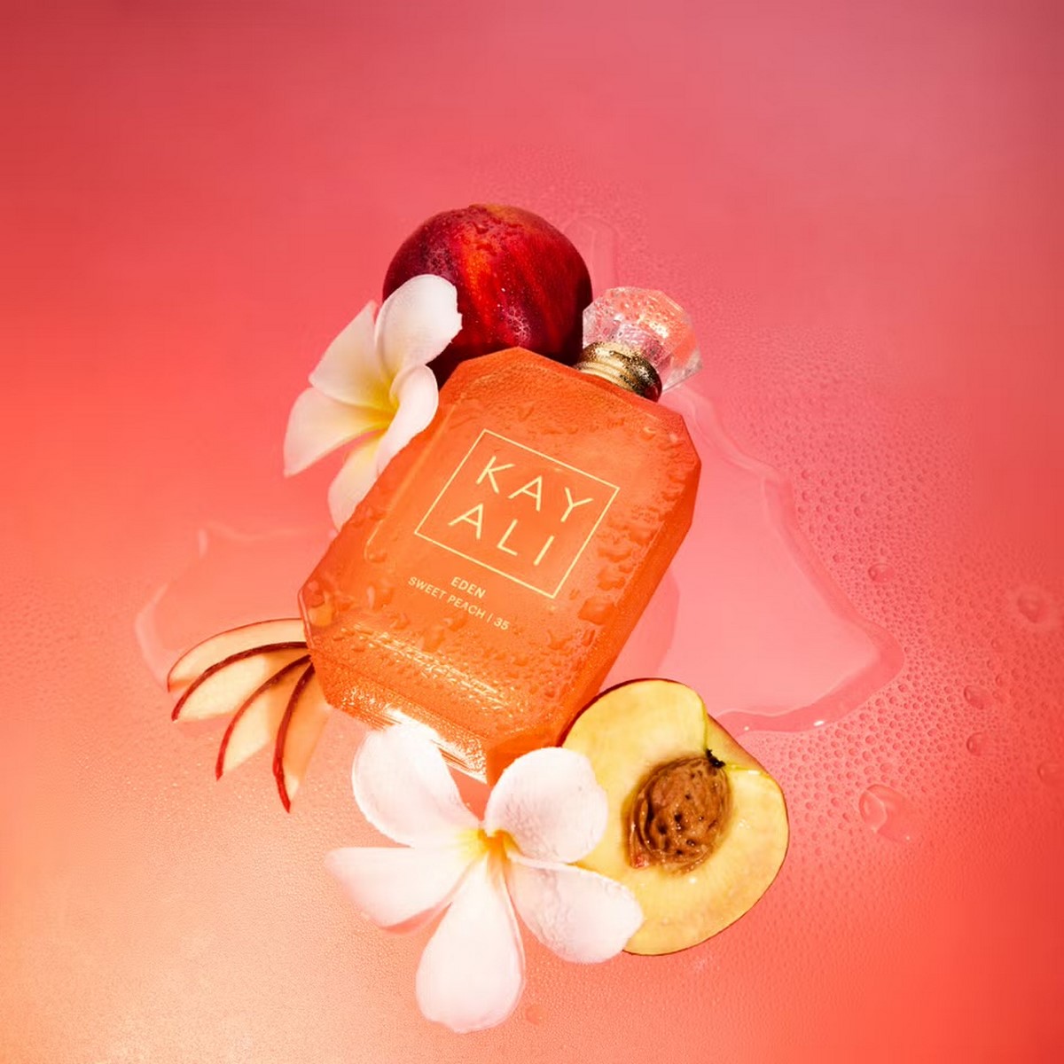 Флакон KAYALI Eden Sweet Peach | 35 Eau de Parfum серед персиків і білих квітів