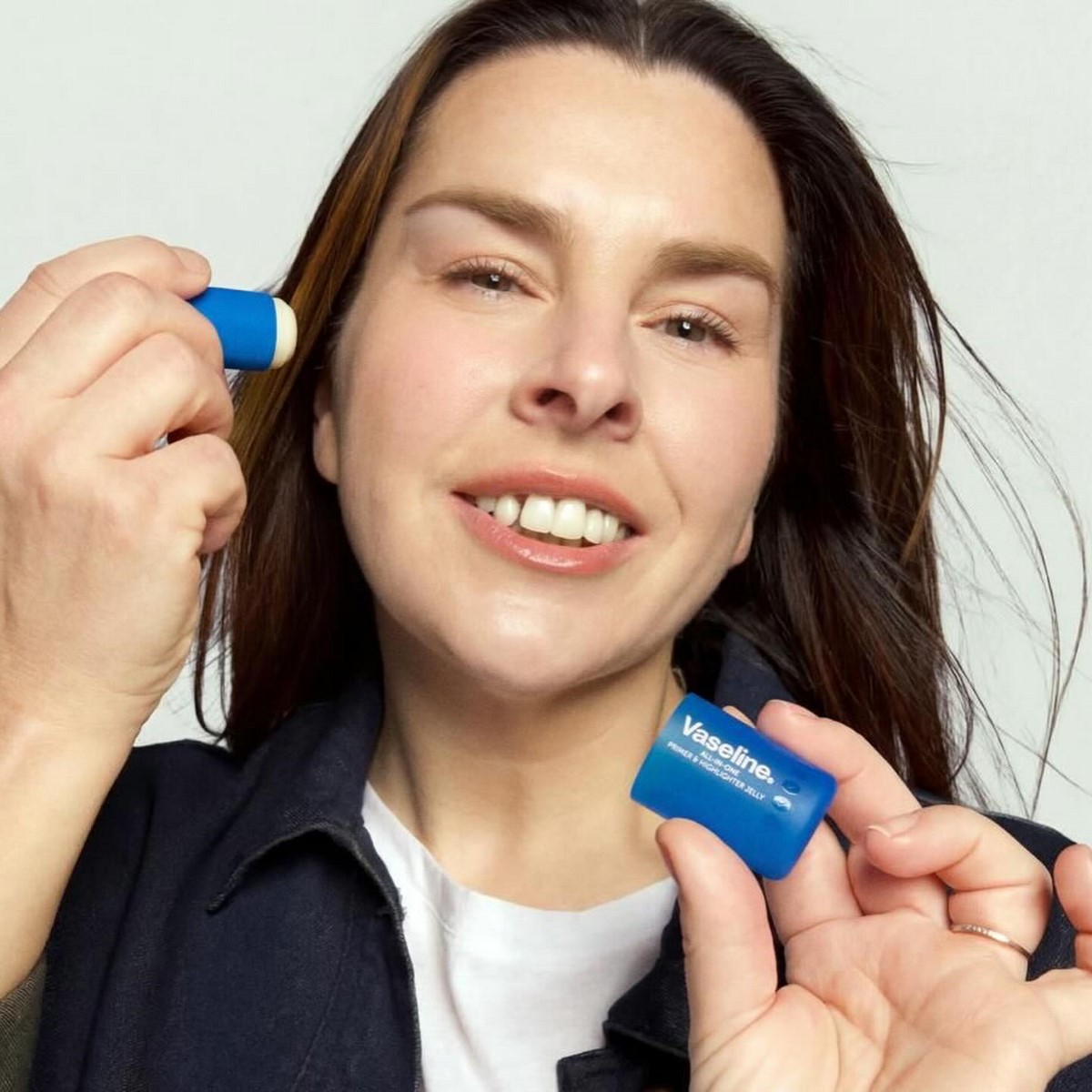 Жінка наносить праймер-хайлайтер Vaseline All-In-One Primer & Highlighter Jelly на вилицю