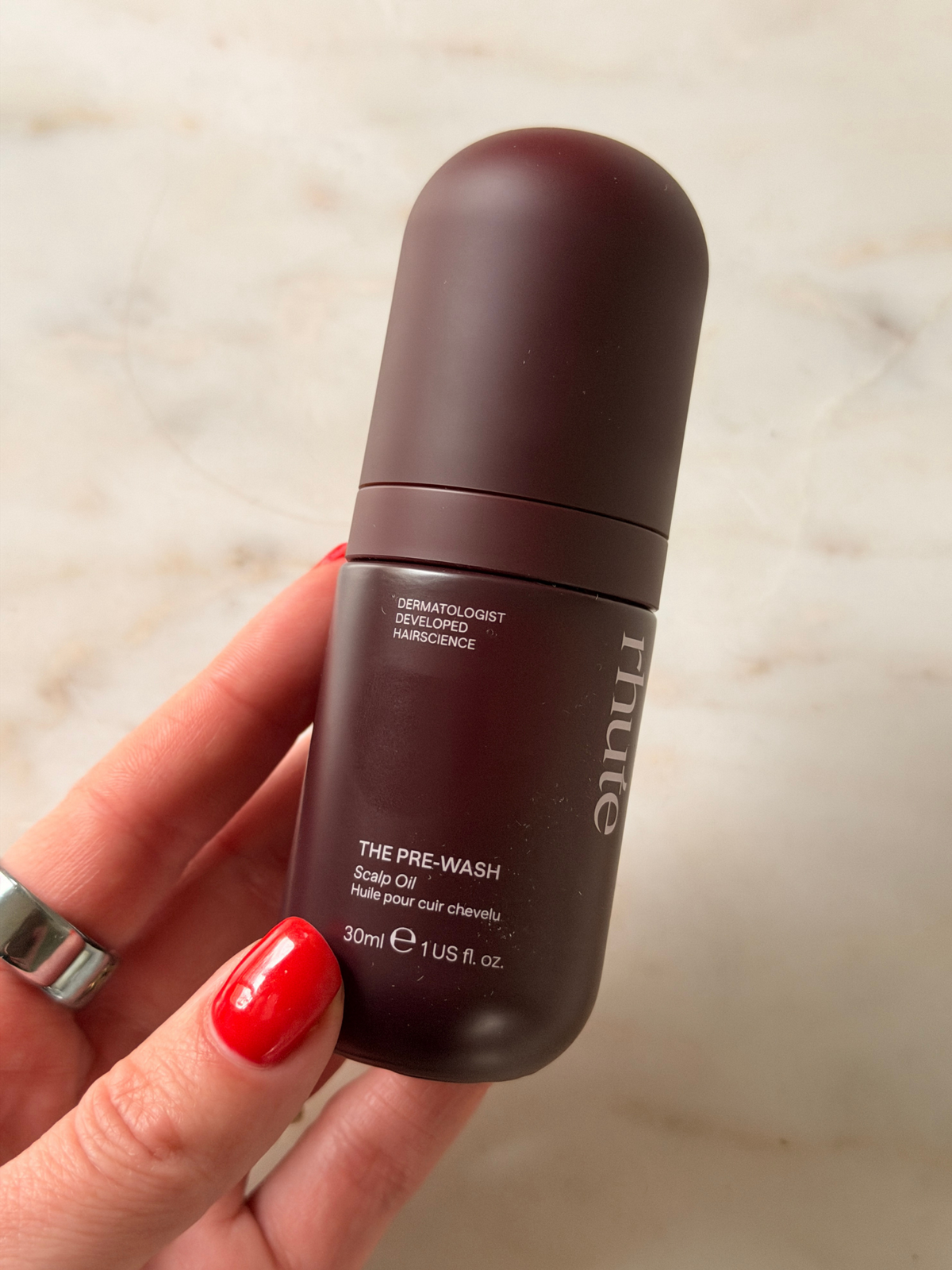 Флакон олії для шкіри голови The Pre-Wash Scalp Oil у руці