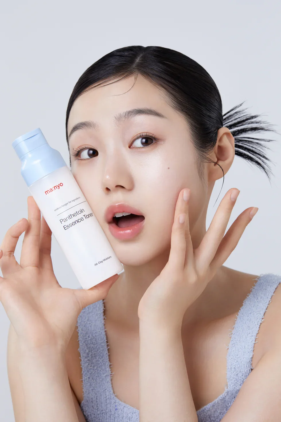 Модель тримає флакон ma:nyo Panthetoin Essence Toner