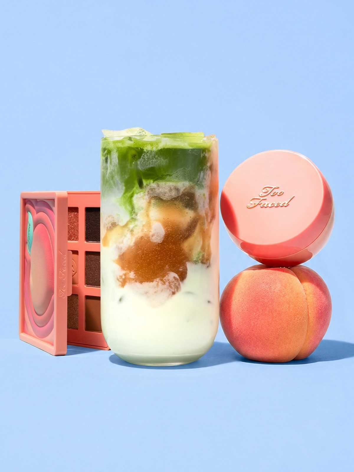 Too Faced Peach Collection з палеткою, пудрою і персиком на блакитному фоні