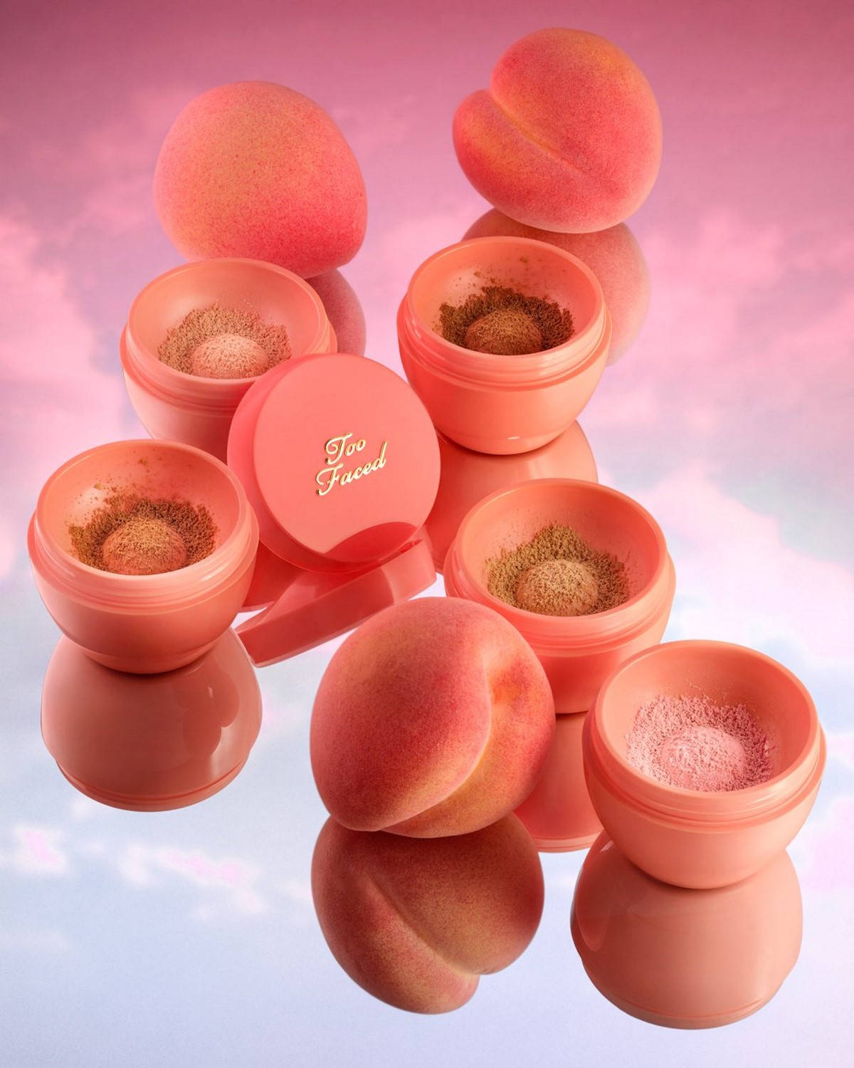 Too Faced Peach Perfector Loose Setting Powder у кількох відтінках поруч із персиками