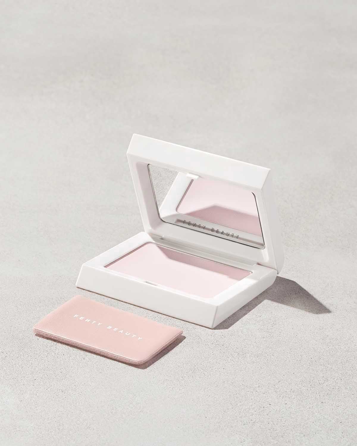 Компактна пудра Fenty Beauty у білому футлярі з дзеркалом та рожевою пуховкою поруч